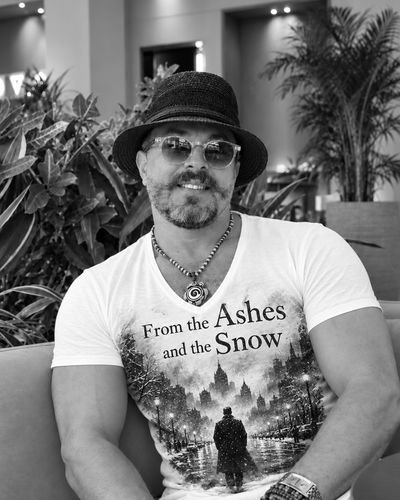 Black-and-white portrait of Mohamed Zerouali Omari in a dark hat and light sunglasses.